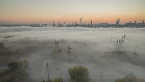 the sun rises over a river valley filled with fog