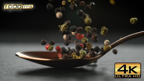Colorful Peppercorns Falling onto Spoon in Slow Motion