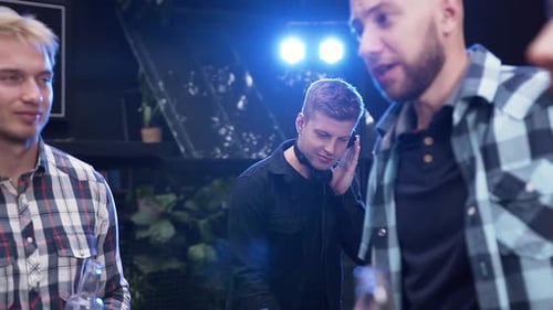 DJ Adjusts Headphones at Night Party