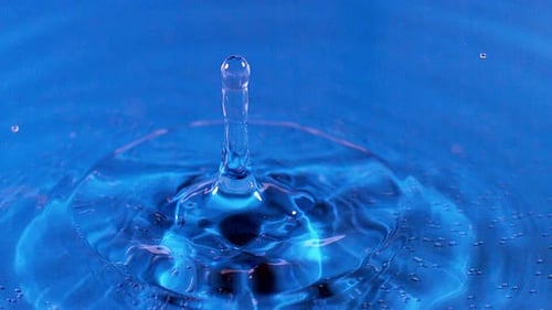 700683 Drop of Water falling into Water against Blue background, Slow motion