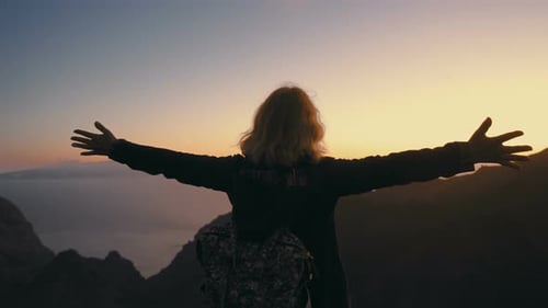 the Woman Meets the Sunset on the Mountain Top and Spreads Her Arms Wide with Delight