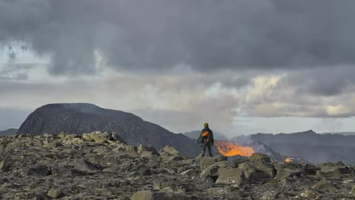 Man Watching Lava Flow From Erupting Fagradalsfjall Volcano In Iceland