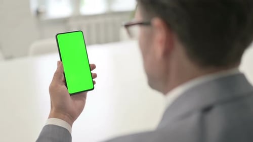 Man using Smartphone with Green Chroma Screen