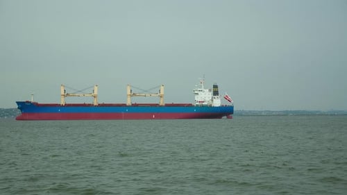 Timelapse of Red Cargo Grain Ship Floats on the Calm Sea
