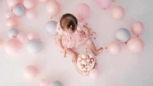 Baby Girl's First Birthday with Balloons and Cake