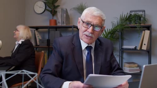 Senior Business Company Manager sitzt am Schreibtisch und liest Lebenslauf Erfolgreiches Vorstellungsgespräch