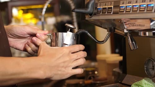 Barista Steaming Milk in Coffee Shop Close-up