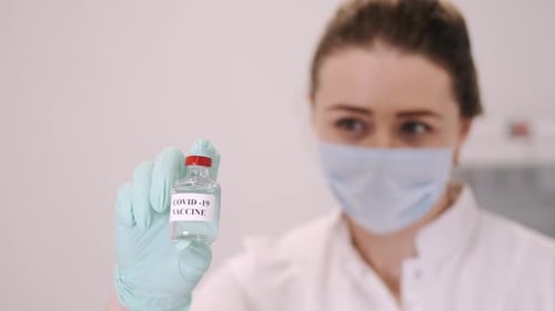 Female Doctor with Prescription Notepad Showing Covid19 Vaccine