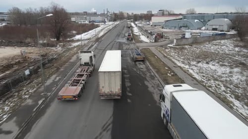 Trucks Travel Road in Industrial Area During Winter