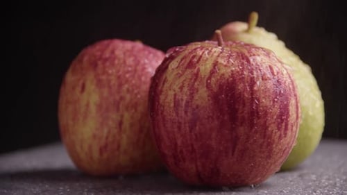 Juicy ripe organic fruits slowly rotate on a black background