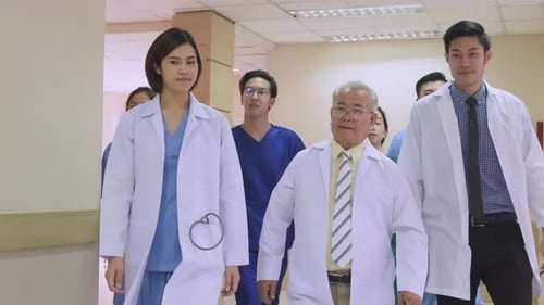 Group of Asian team of doctors, nurses and assistants walking through the hallway of the hospital.