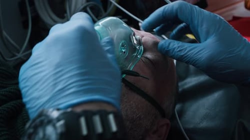 Crop Paramedic Adjusting Respirator on Patient