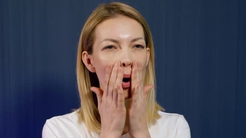 Woman Doing Facial Massage Against Blue Backdrop