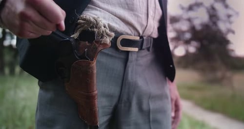 Man Draws Revolver From Leather Holster Outdoors