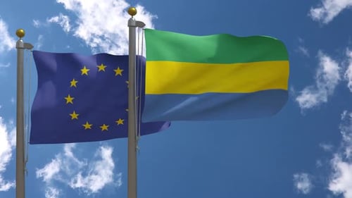 European Union And Gabon Flags Waving In Blue Sky