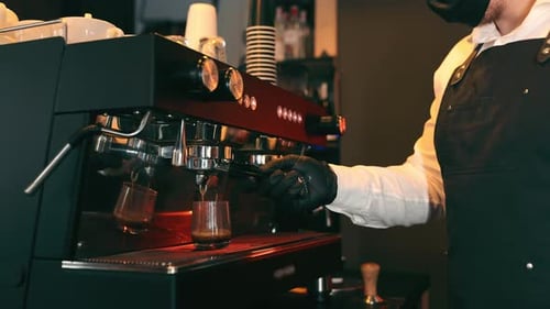 Male Barista in Face Mask is Making a Cappuccino in a Coffee Shop Bar