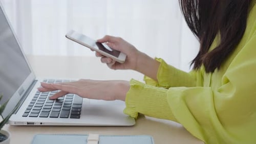 Closeup hand of young asian businesswoman working on laptop computer on desk at home office.