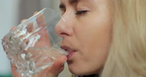 Close Up of Woman Holding Glass Drinks Still Water Preventing Dehydration Helps Maintain Normal