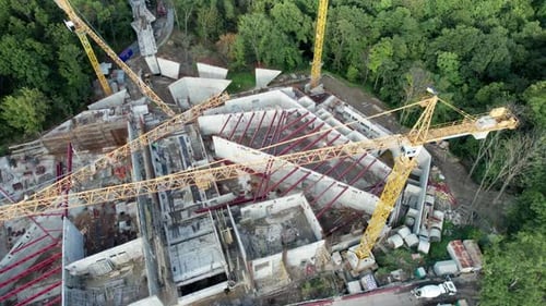 Aerial View Construction of a New Building with High Tower Cranes in Green Area