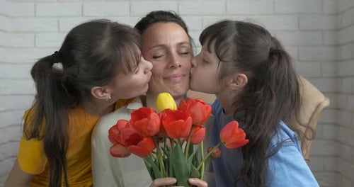 Mother with Two Daughters Holding Flowers