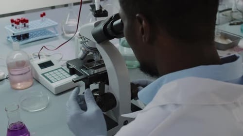 Scientist Using Microscope for Medical Research in Lab
