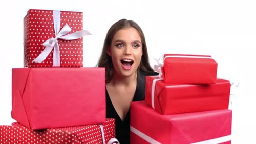 Smiling Woman Holding a Stack of Beautiful Birthday Gifts