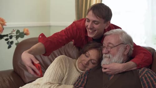 Young Man Taking Selfie With Grandparents at Home