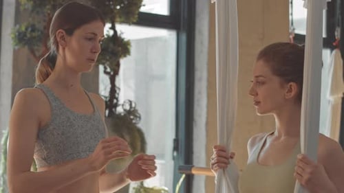 Women Discussing Aerial Yoga in Fitness Studio