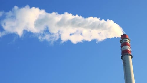 Ein Smokestack strahlt Rauch aus - der klare blaue Himmel im Hintergrund