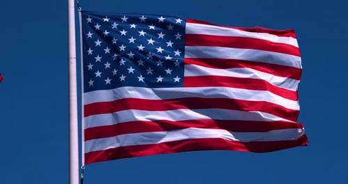 American Flag Waving Against Blue Sky