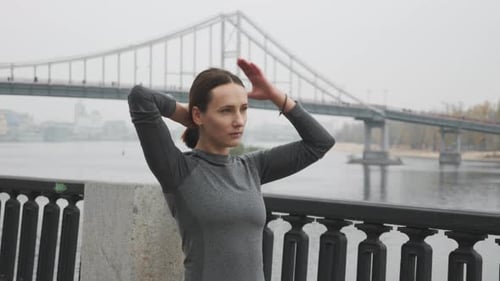 Woman Puts Hair Up Near the River