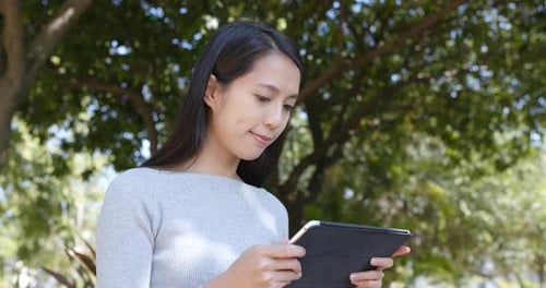Woman Using Tablet in Urban Park Environment
