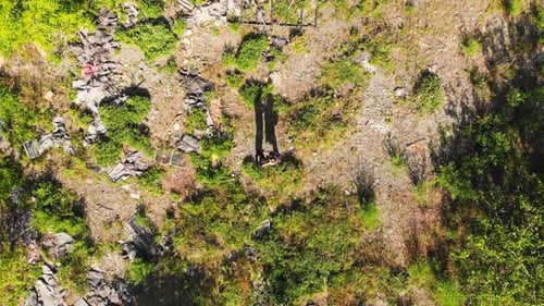 Aerial view Of Couple Hugging In A green Field Around wasteland