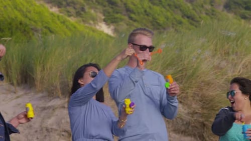 Group of friends at beach blowing bubbles