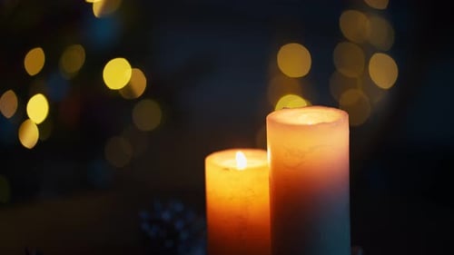 Nahaufnahme brennender Kerzen über verschwommenen Weihnachtslichtern