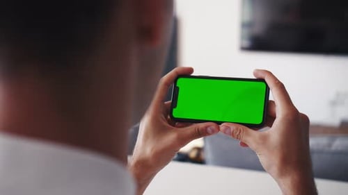 Rare Close-up of the Unrecognizable Man Holding Green Screen Smartphone in Landscape Mode and