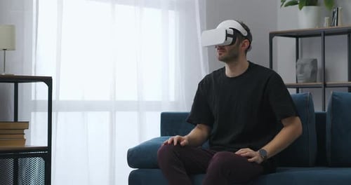 Man Wearing VR Headset Sitting on Couch