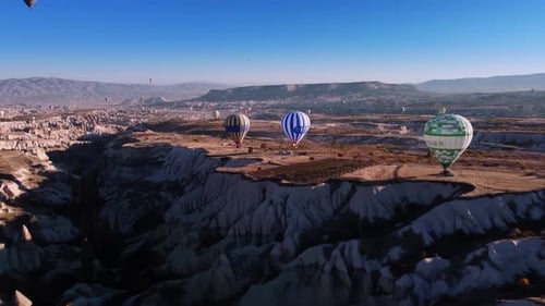 Levitating Hot Air Balloons Over Cappadocia Valley with Volcanic Sandstone Hills Filmed By Drone