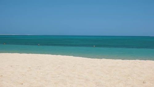 Seascape with Surface of Blue Sea Water with Small Ripple Waves Crashing on Yellow Sandy Beach