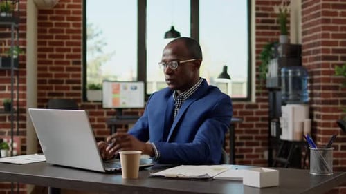 Adult Man Thinking in Office with Laptop