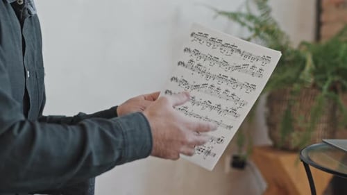 Man Holding Papers with Musical Notes