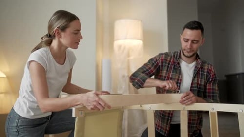 Young Adults Moving in New Home, Couple Moving in Assembling Chair Furniture, Young Interracial