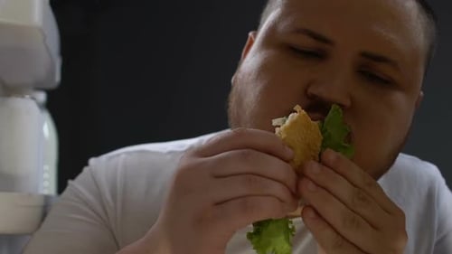 Man Eating Burger with Lettuce Close Up