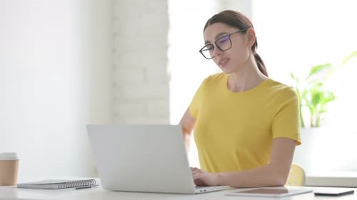 Woman having Back Pain while using Laptop in Office
