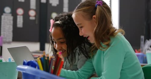 Side view of Mixed-race schoolgirls studying on laptop in the classroom 4k