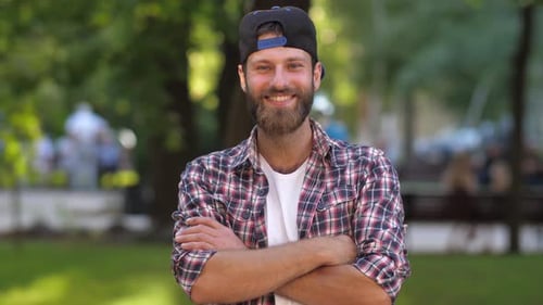 Bearded Man Smiling in Urban Park Setting