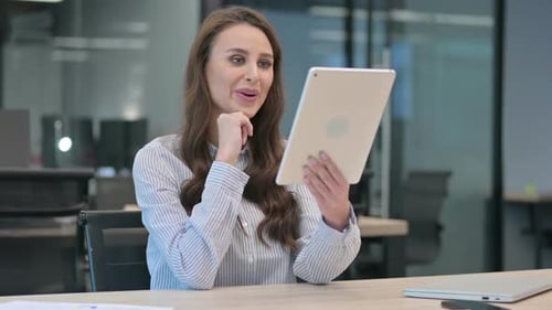 Woman Video Conferencing on Tablet in Office