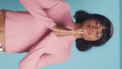 Woman Rubbing Hands on Her Face on Blue Background