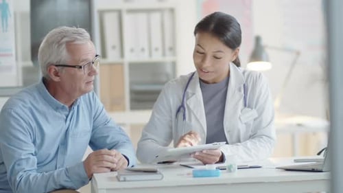 Doctor Showing Patient Results on Tablet in Office