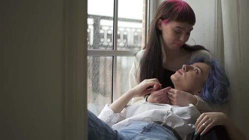 Loving Couple Hold Hands by a Window